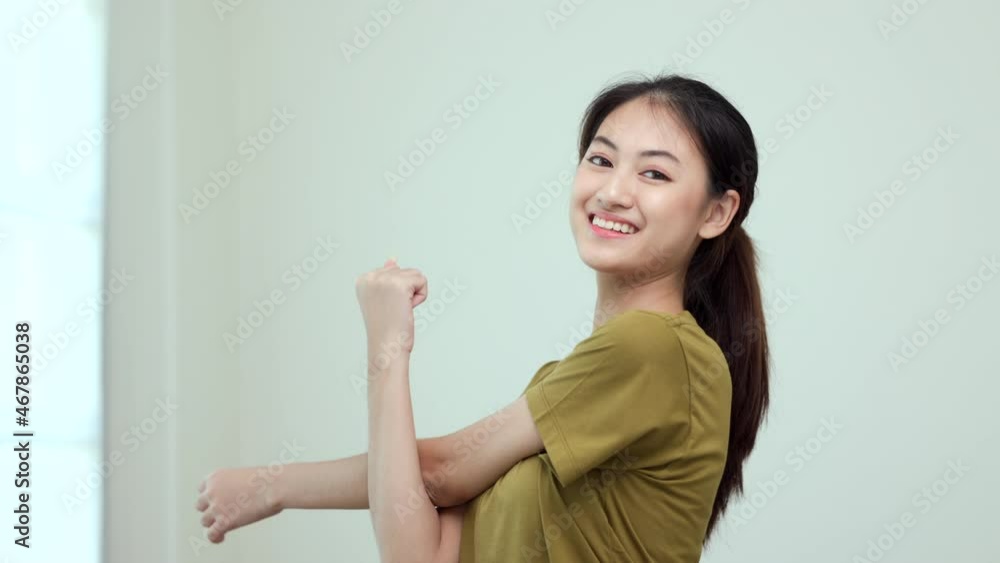 Attractive asian young fitness woman stretching arms warming up before workout at home. Beautiful smiling Female wearing sportswear exercise training yoga in living room. Attractive asian young fitness woman stretching arms warming up before workout at home. Beautiful smiling Female wearing sportswear exercise training yoga in living room.