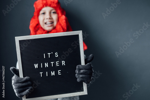 Cute boy with happy expression wearing winter clothes welcomes winter season 