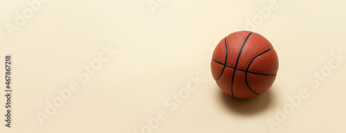 Close up of brown basketball ball isolated on beige background. Sport team concept. Horizontal sport theme poster, greeting cards, headers, website and app © Augustas Cetkauskas