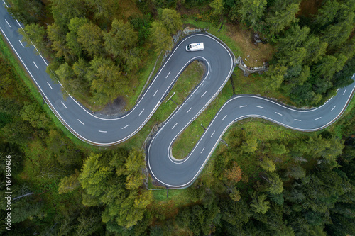 Drone view of single car driving along winding Maloja Pass road