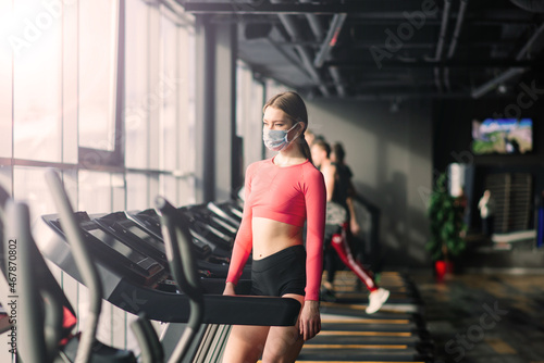 Woman wearing face mask exercise workout in gym during corona virus pandermic.