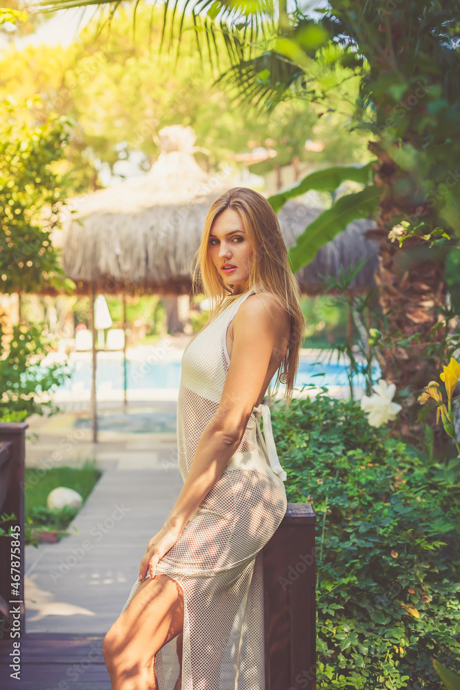Beautiful young woman in a green tropical garden
