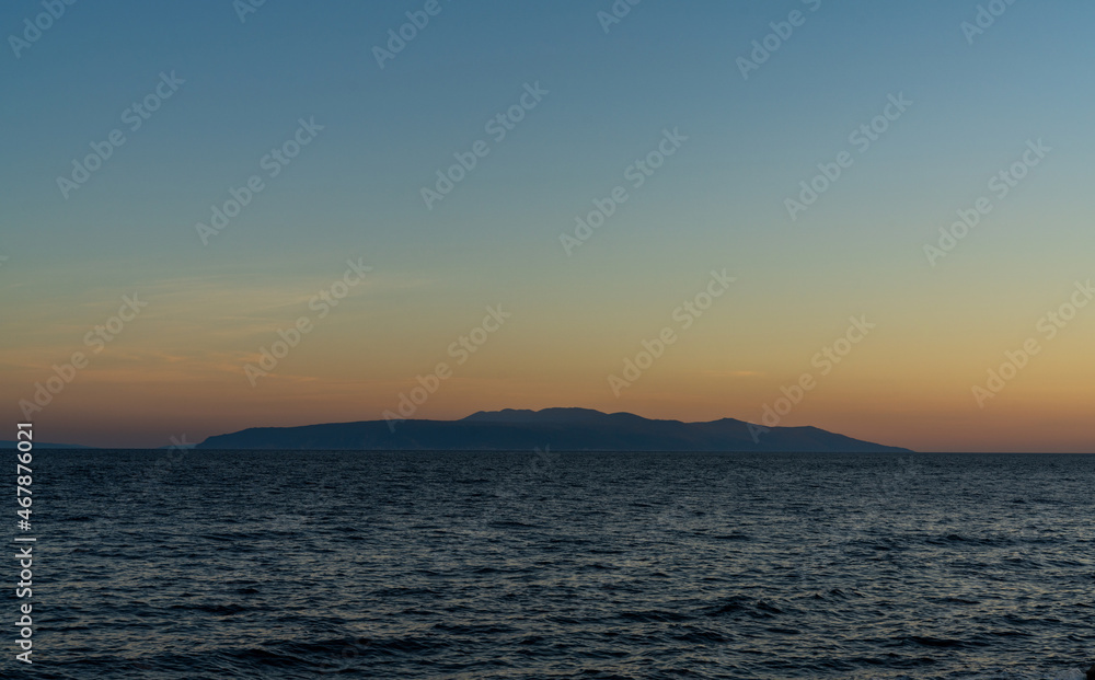 view of the Bay of Kvarna with the silhouette of Cres Island at sunset