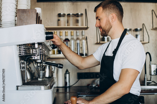 Male barista preparing coffee in a coffee shop
