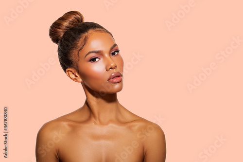 Beauty. Portrait of Afro American Woman perfect Healthy radiant Skin, light pink Makeup. Isolated. Close-up. Fashionable Black Woman over Peach Background. Make-up. 