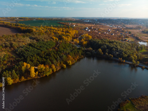 Fototapeta Naklejka Na Ścianę i Meble -  Aerial view of sunrise in autumn. top down. Meadows, orange grass, trees at dawn. Colorful landscape of river coast at sunset in fall. Plowed fields, harvested crops, dry corn. Horodok Ukraine