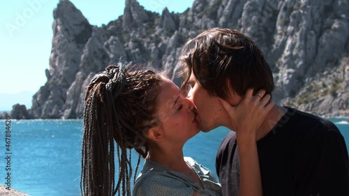 Young pretty couple kissing on a background of a sea bay
