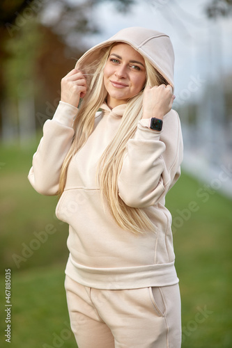 A young girl in a tracksuit stands in a city park