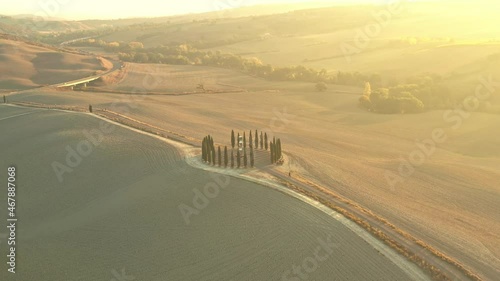 Aerial view of the beautiful hills of the Val d'Orcia in Tuscany with the cypress circle shape grove near Montalcino, Italy, hills cultivated with wheat, Ionic column by Helidon Xhixha, Reflexes photo