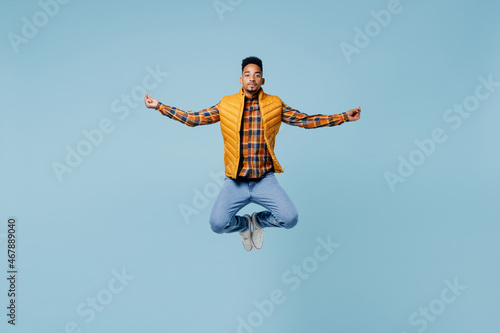 Full size body length young black man 20s wears yellow waistcoat shirt hold spreading hands in yoga om gesture meditate try to calm down isolated on plain pastel light blue background studio portrait.