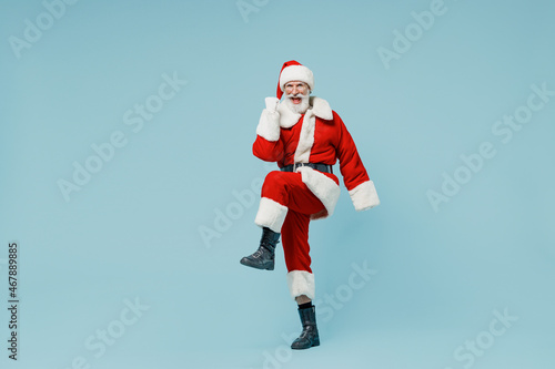 Full body happy old Santa Claus man 50s in Christmas hat red suit clothes do winner gesture isolated on plain blue background studio. Happy New Year 2022 celebration merry ho x-mas holiday concept