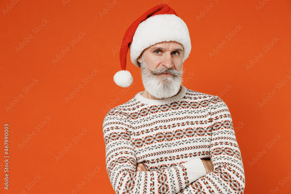 Old aggrieved disconcerted sad upset fatigued tired bearded Santa Claus man 50s wear Christmas hat sweater posing looking camera hold hands crossed frowning isolated on plain orange background studio Old aggrieved disconcerted sad upset fatigued tired bearded Santa Claus man 50s wear Christmas hat sweater posing looking camera hold hands crossed frowning isolated on plain orange background studio
