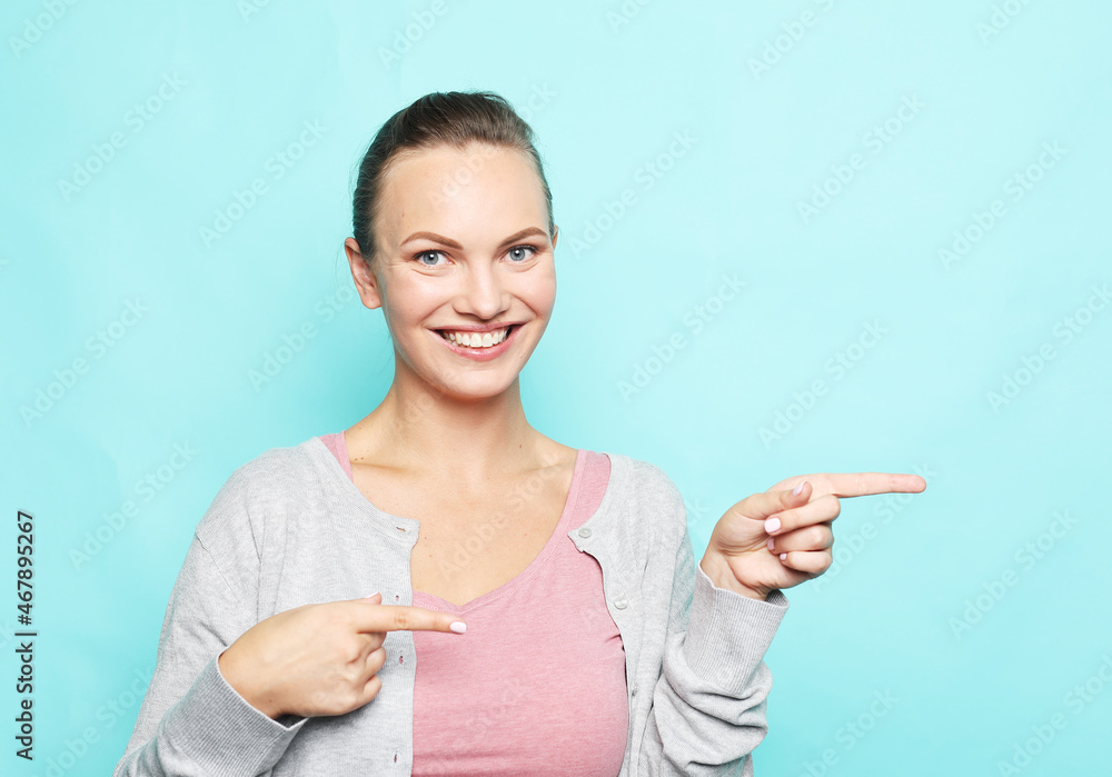 Young woman pointing with finger at blank copy space aside, happy positive female show at vacant advertising spot Young woman pointing with finger at blank copy space aside, happy positive female show at vacant advertising spot