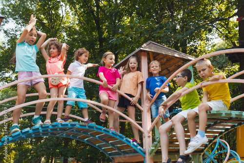 The little kids stand on a bridge in the playground