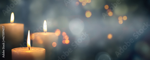 Photo closeup of 3 burning candles on abstract black background, contemplate celebrati