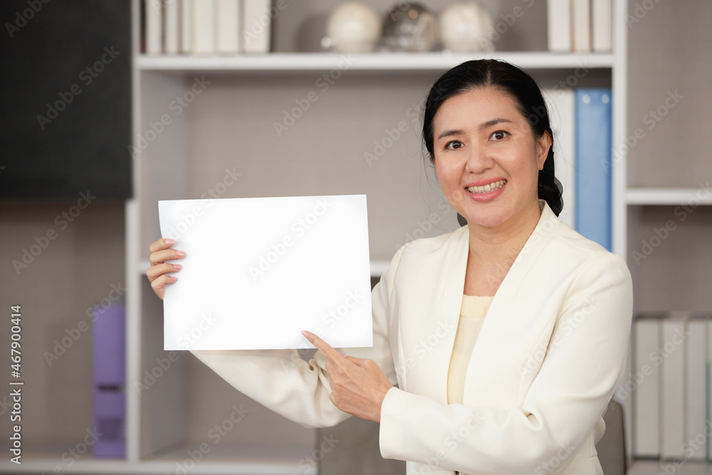 Asian Business woman standing smile hand pointing at blank paper space for text Asian Business woman standing smile hand pointing at blank paper space for text