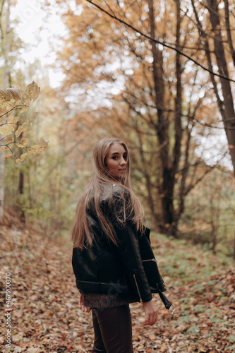 beautiful girl with blonde long hair in autumn park