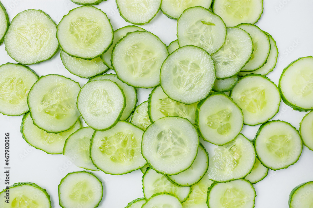 Slices of fresh cucumber pattern on white background, top view. Slices of fresh cucumber pattern on white background, top view.