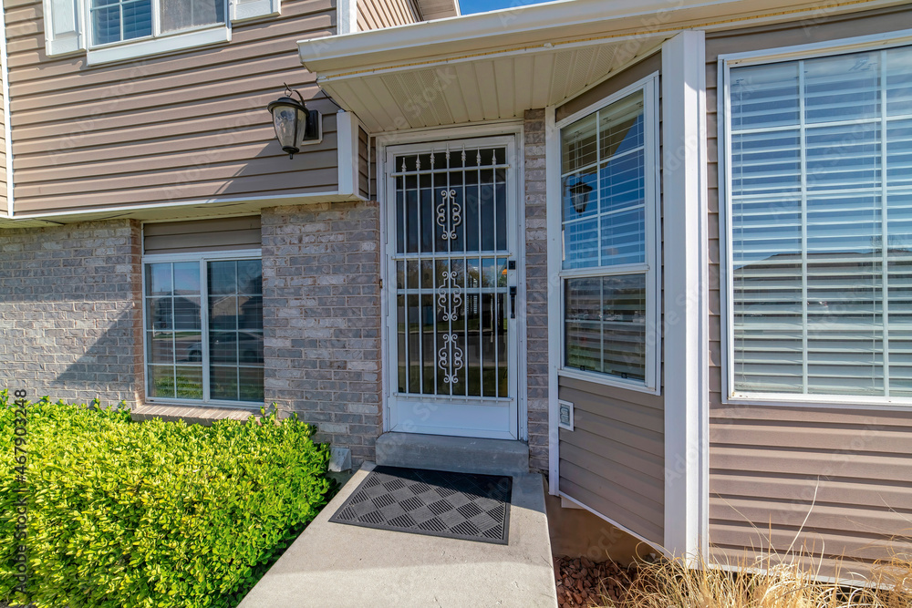 Front exterior of a house with security doors and wall lighting