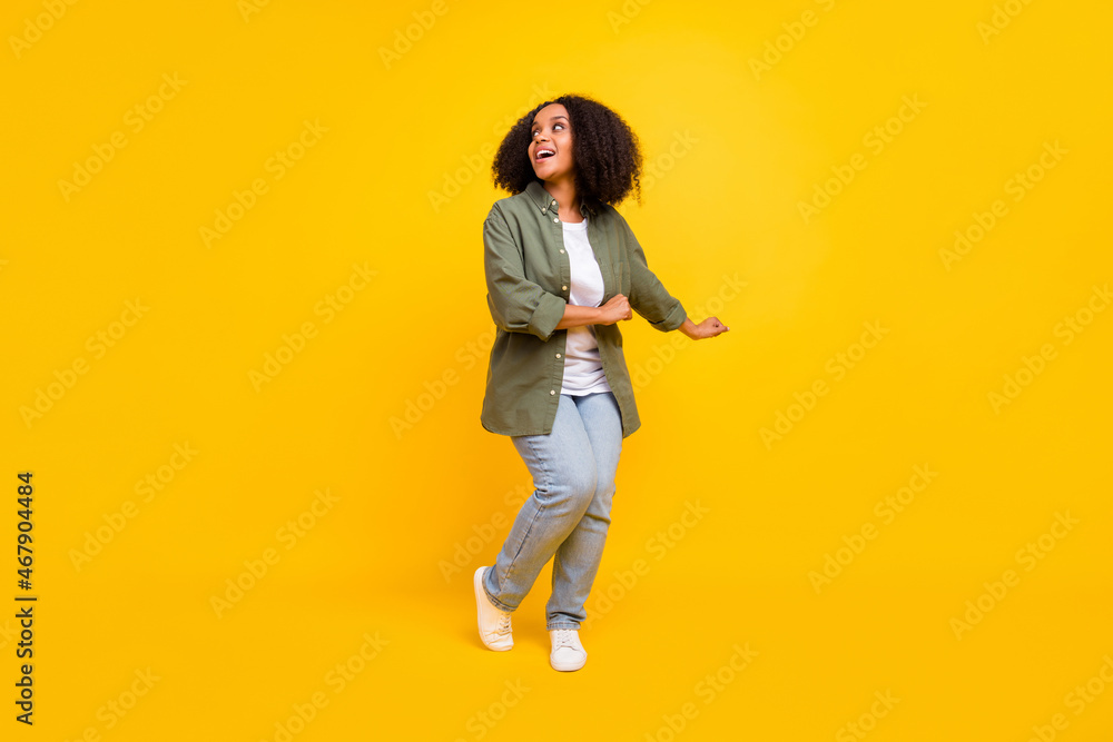 Full length photo of cool brunette millennial curvy lady dance wear shirt jeans footwear isolated on yellow color background
