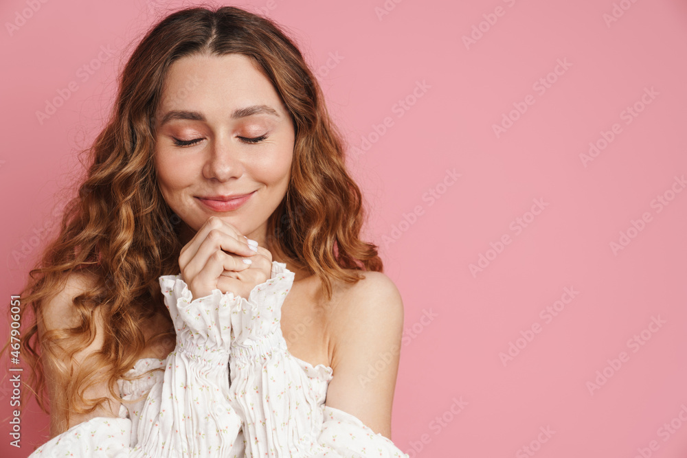 Young ginger woman in dress smiling while posing with her eyes closed Young ginger woman in dress smiling while posing with her eyes closed