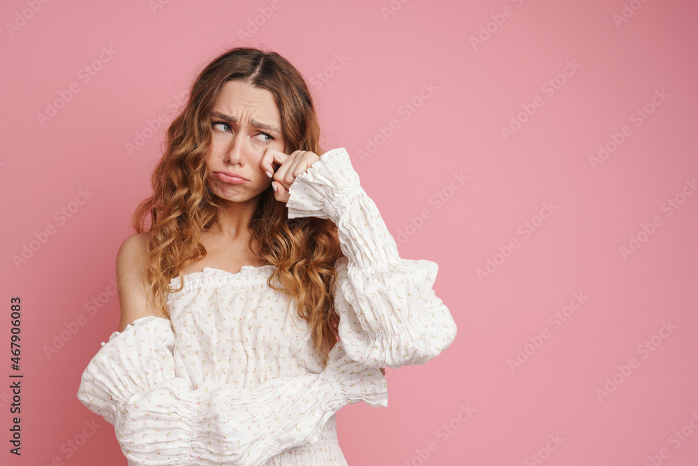 Young ginger woman in dress wiping her tears while crying Young ginger woman in dress wiping her tears while crying