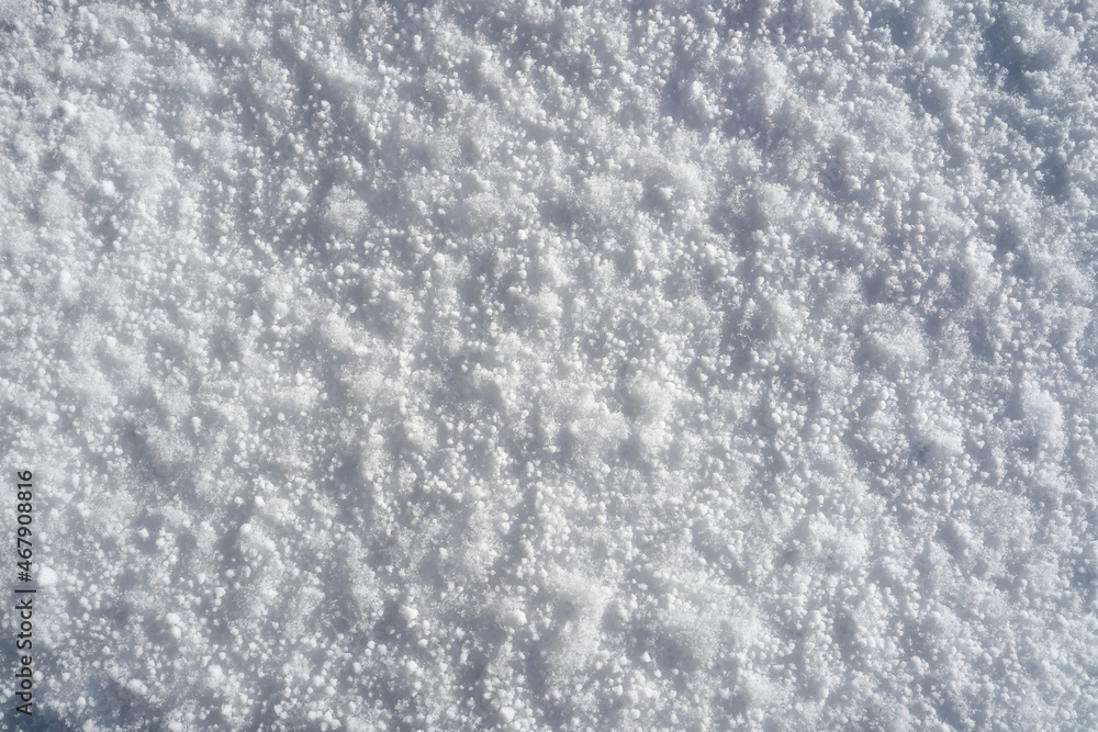 Fine fresh snow pattern texture background on a sunny day from directly above.