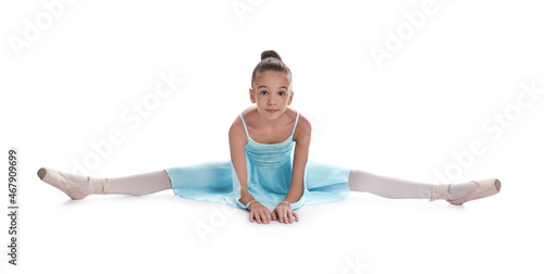 Beautifully dressed little ballerina sitting on split against white background