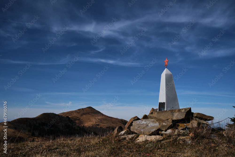 Red star on memorial symbolizes memory and sorrow. Monument to fallen soldiers in war stands on top of mountain. Journey to places of military glory of Second World War.