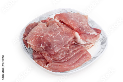 Sliced uncooked pork pulp on dish on white background