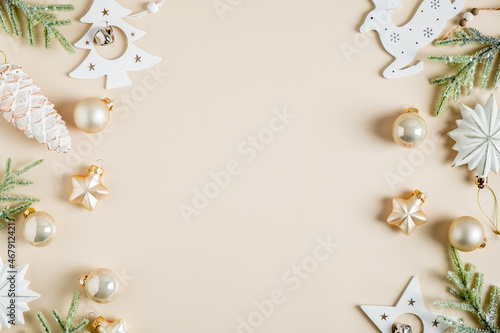 Christmas frame. Elegant Christmas card with fir branches, boho style white stars, baubles, pine cone decoration on beige background. Flat lay, top view, copy space