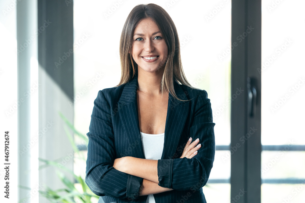 Beautiful young business woman standing while smiling looking at camera in the office. Beautiful young business woman standing while smiling looking at camera in the office.