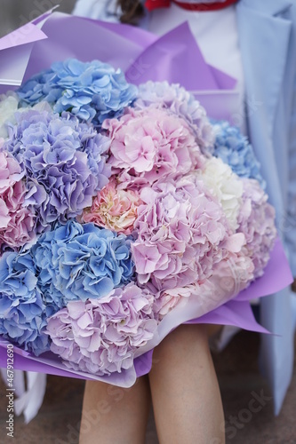 Girl holding bouquet of pastel color flowers/hydrangea