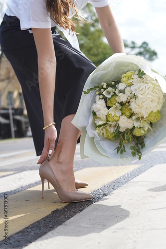 Girl in heels with bouquet of flowers