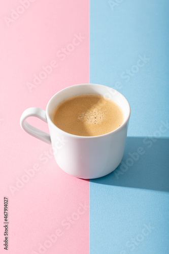 cup of coffee on a pastel pink background, photography with contrast shadow, selective focus