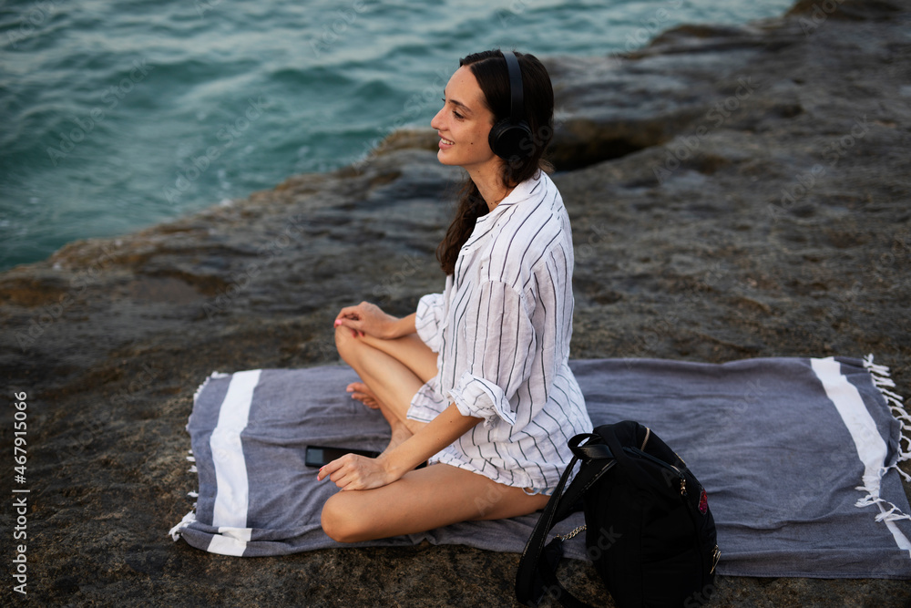 Hot woman relaxing on the sandy beach. Beautiful woman with headphones listening the music.. Hot woman relaxing on the sandy beach. Beautiful woman with headphones listening the music..