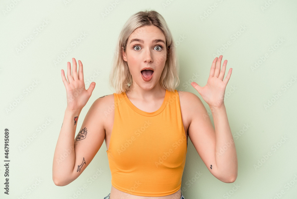 Young caucasian woman isolated on green background celebrating a victory or success, he is surprised and shocked. Young caucasian woman isolated on green background celebrating a victory or success, he is surprised and shocked.