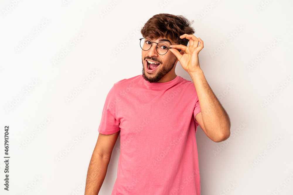 Young mixed race man isolated on grey background excited keeping ok gesture on eye. Young mixed race man isolated on grey background excited keeping ok gesture on eye.
