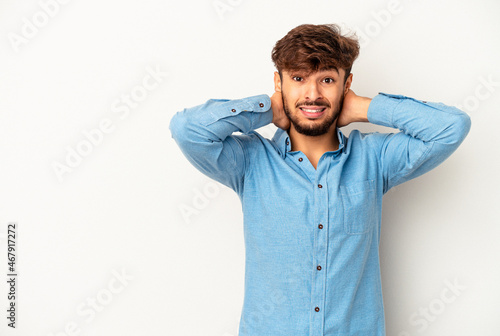 Young mixed race man isolated on grey background touching back of head, thinking and making a choice.