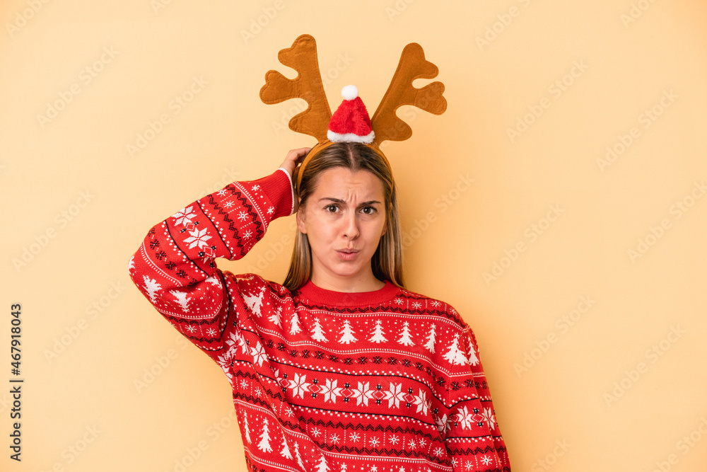 Young caucasian woman wearing a christmas reindeer hat isolated on yellow background being shocked, she has remembered important meeting. Young caucasian woman wearing a christmas reindeer hat isolated on yellow background being shocked, she has remembered important meeting.