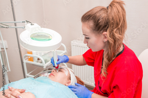 Cosmetology mesotherapy for facial rejuvenation. Mikronidling cosmetic procedure. The beautician injects hiluronic acid in the face of the girl's patient with the help of a dermopen wrinkle remover.