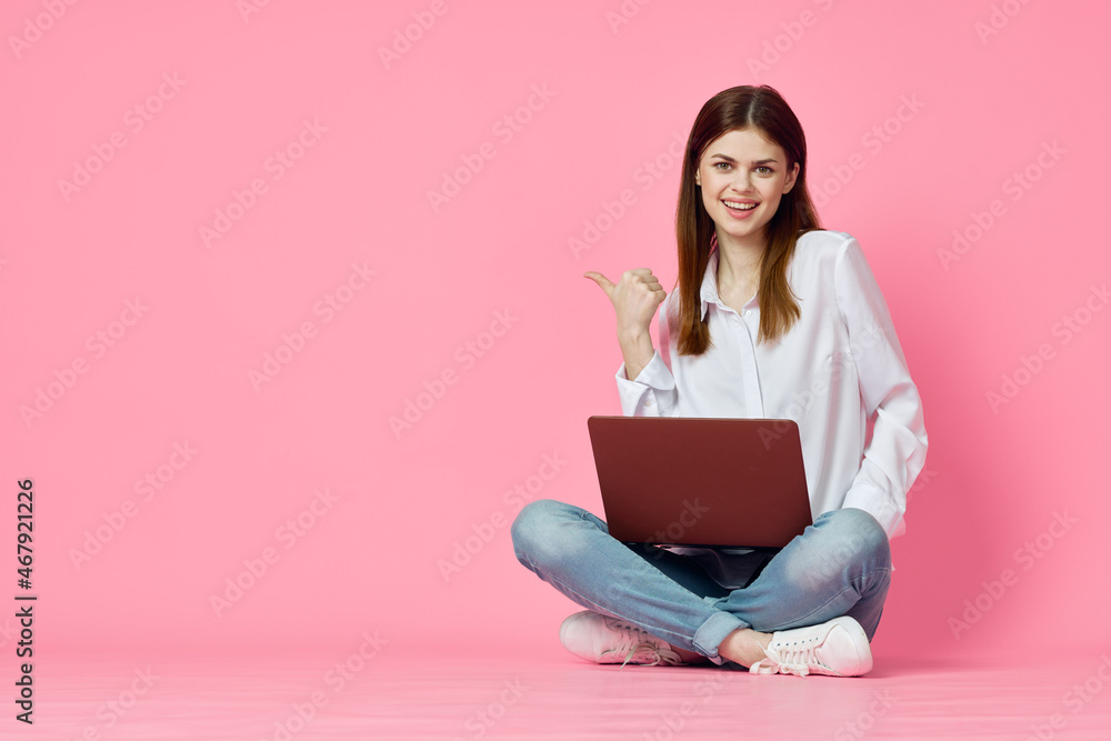 woman sitting on floor with laptop shopping entertainment pink background woman sitting on floor with laptop shopping entertainment pink background