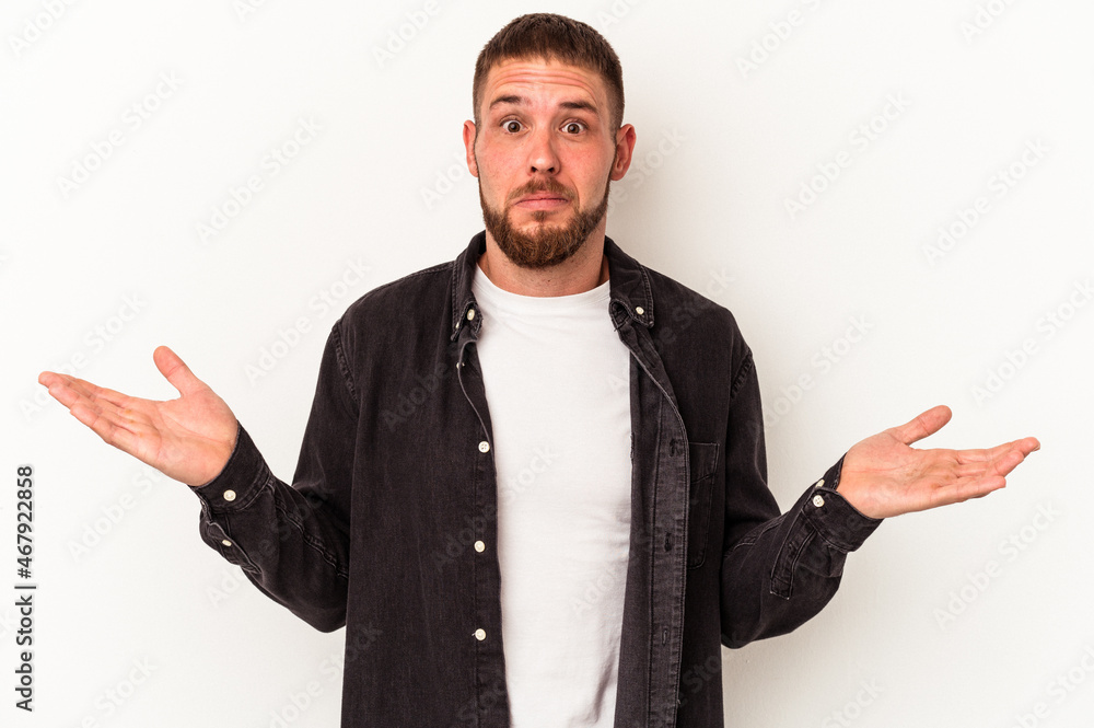 Young caucasian man with diastema isolated on white background shrugs shoulders and open eyes confused. Young caucasian man with diastema isolated on white background shrugs shoulders and open eyes confused.