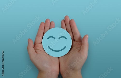 Fotografía Hand holding blue paper cut happy smile face, positive thinking, mental health a