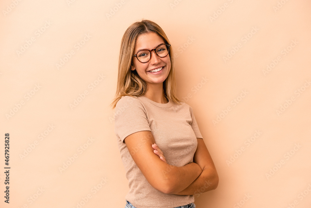 Young caucasian woman isolated on beige background happy, smiling and cheerful. Young caucasian woman isolated on beige background happy, smiling and cheerful.