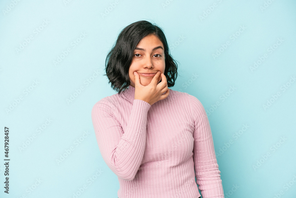 Young latin woman isolated on blue background doubting between two options. Young latin woman isolated on blue background doubting between two options.