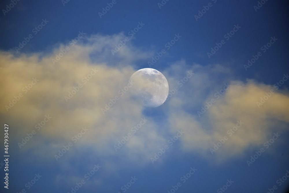 the moon streaked with clouds in the night sky