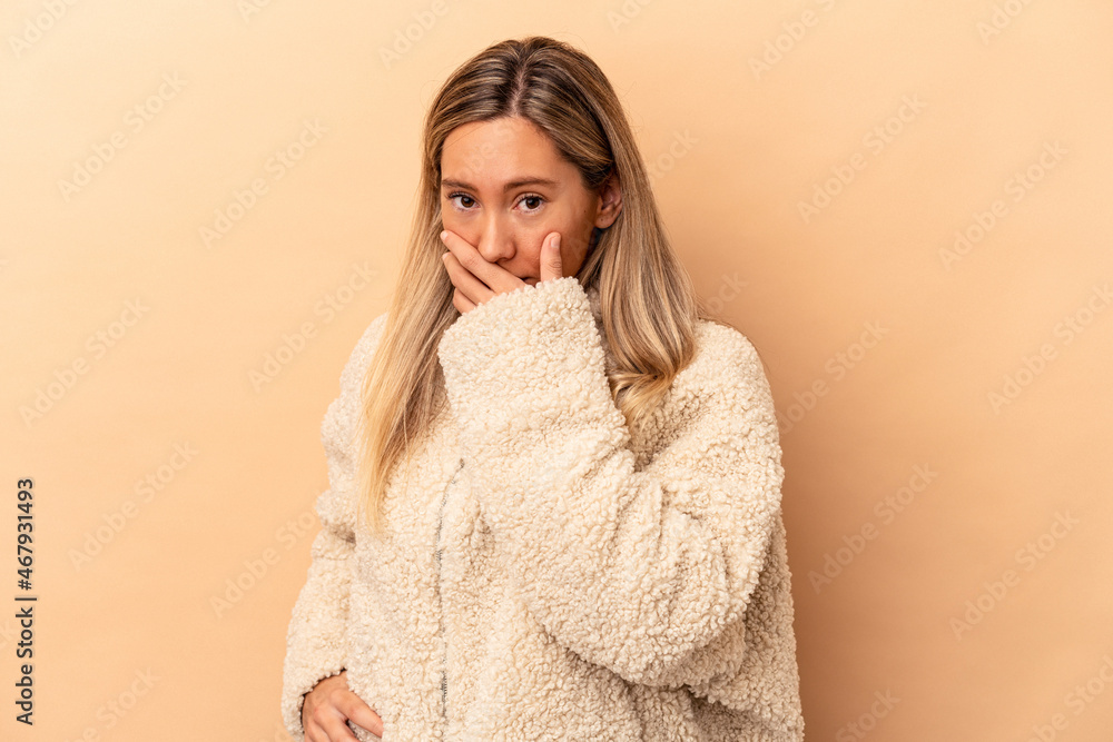 Young caucasian woman isolated on beige background covering mouth with hands looking worried. Young caucasian woman isolated on beige background covering mouth with hands looking worried.