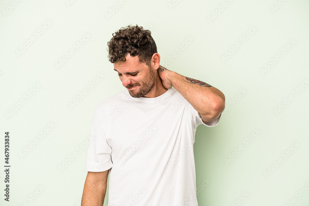 Young caucasian man isolated on green background suffering neck pain due to sedentary lifestyle. Young caucasian man isolated on green background suffering neck pain due to sedentary lifestyle.