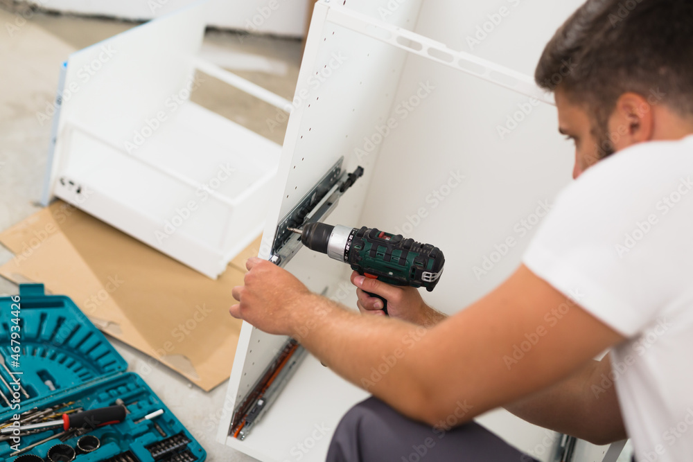 professional worker assembling cabinet indoor